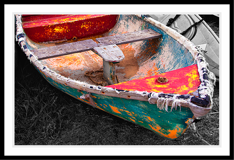 Colorful rowboat aging on the beach.